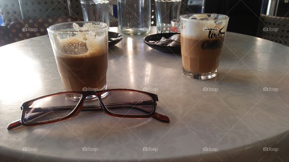 my glasses on table with two cups of my best coffee.