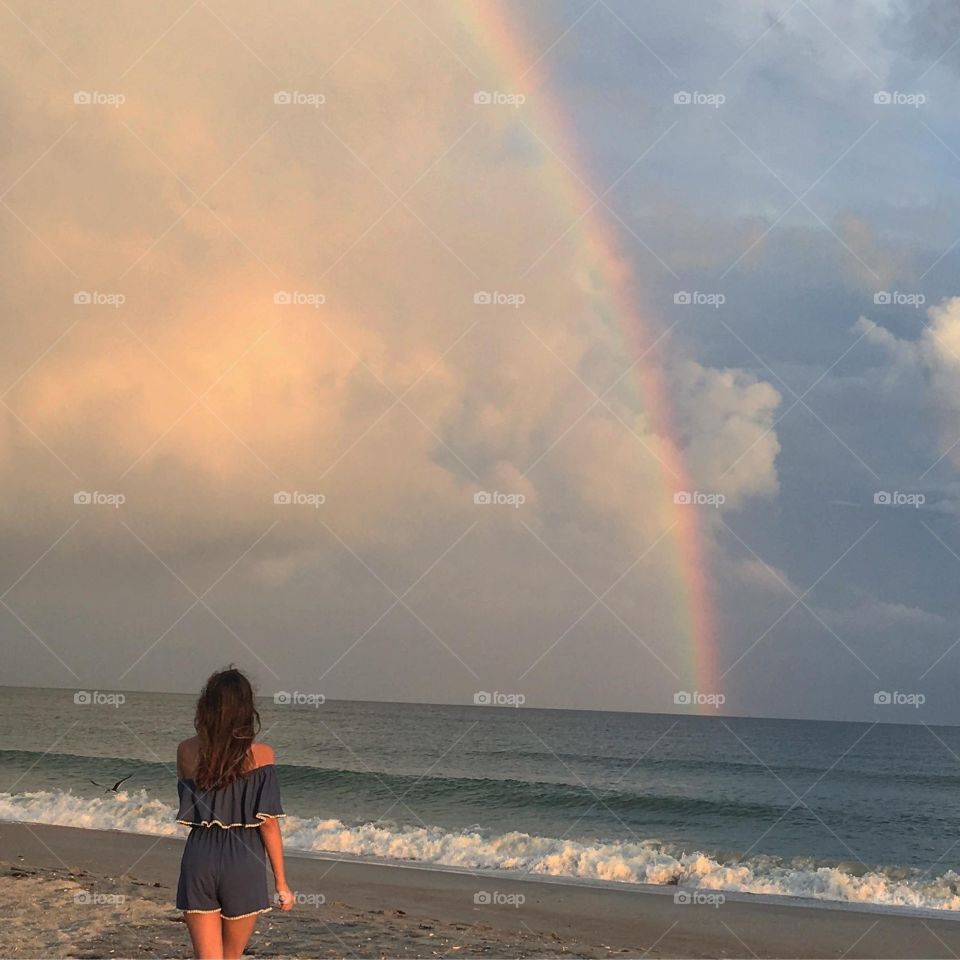 Walking past fear towards rainbow over ocean
