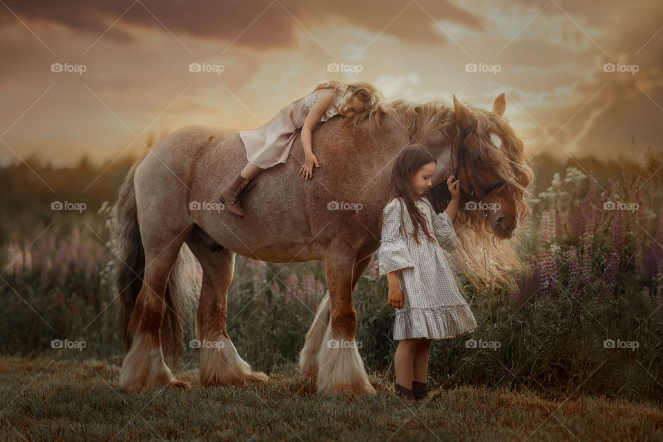 Portrait of little sisters with  horse