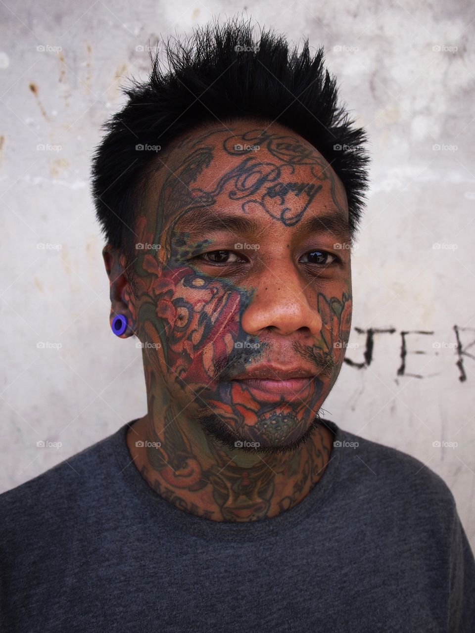 portrait of a man with facial tattoo