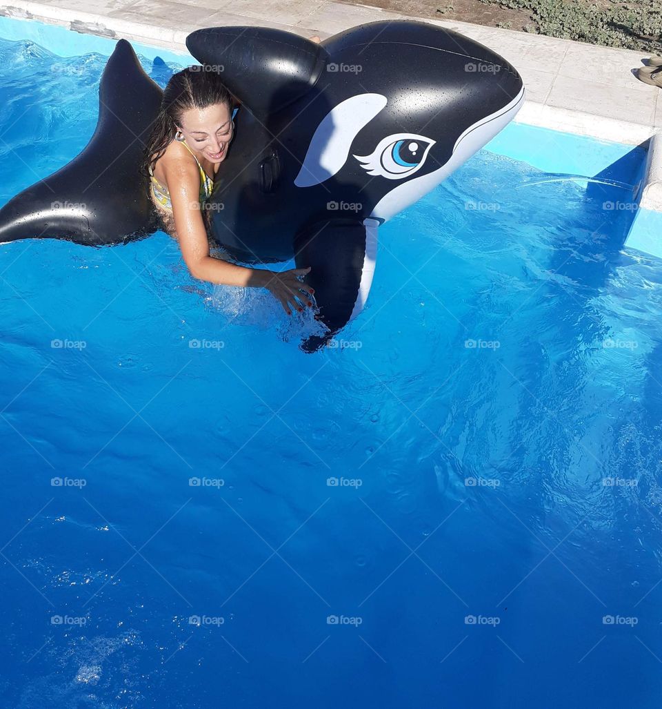 la chica juega con ballena inflable en la pileta