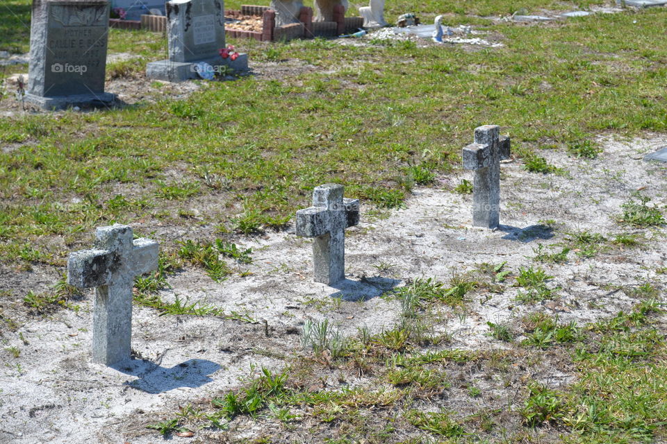 3 concrete crosses in a row at a cemetery