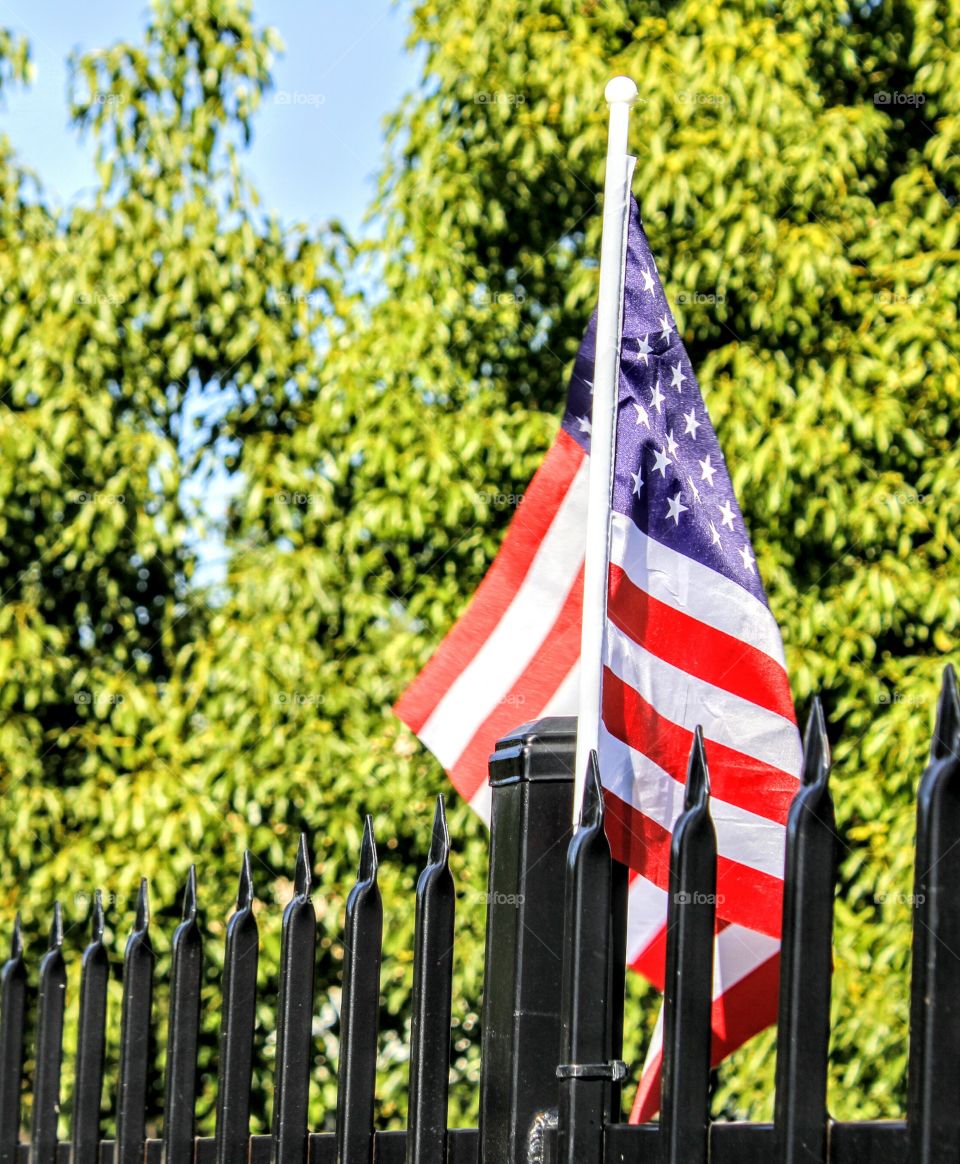 an American flag on an iron fence