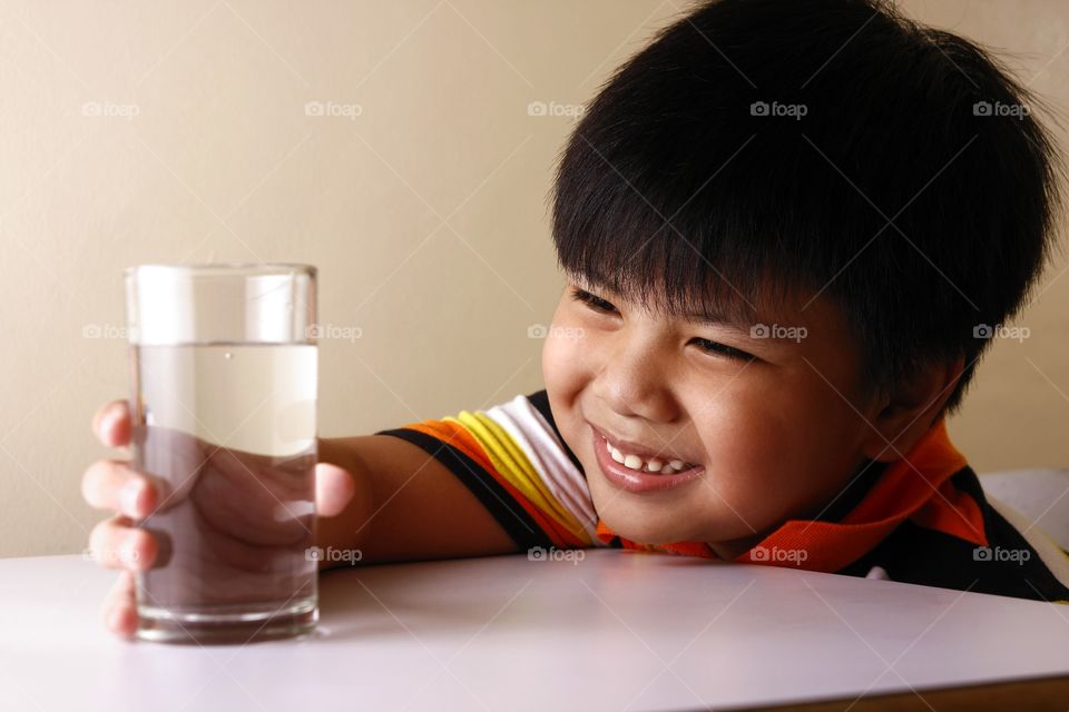 young boy holding a glass of water