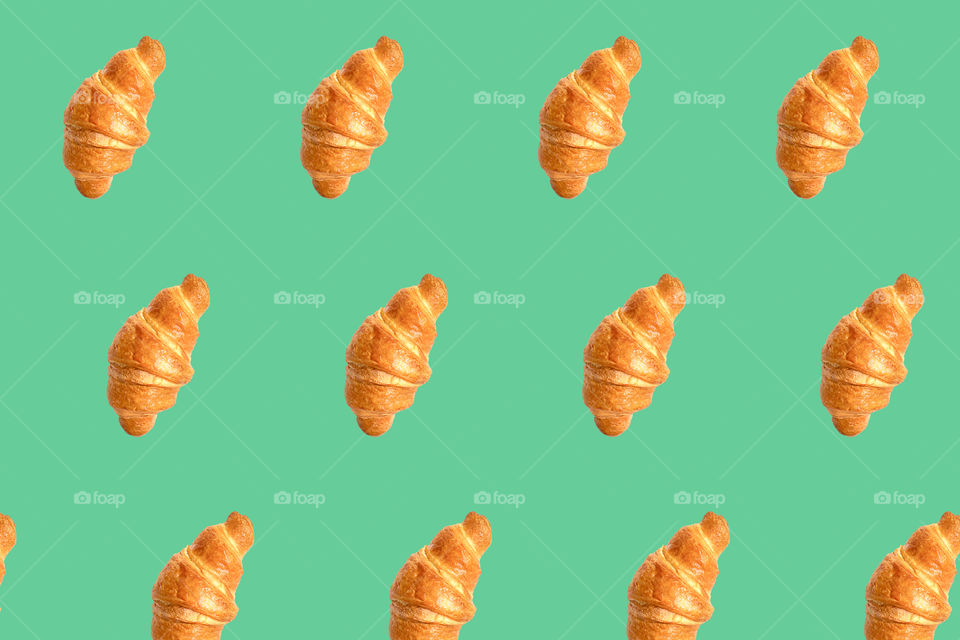 Fresh home made croissants seamless pattern, isolated on green, neo mint