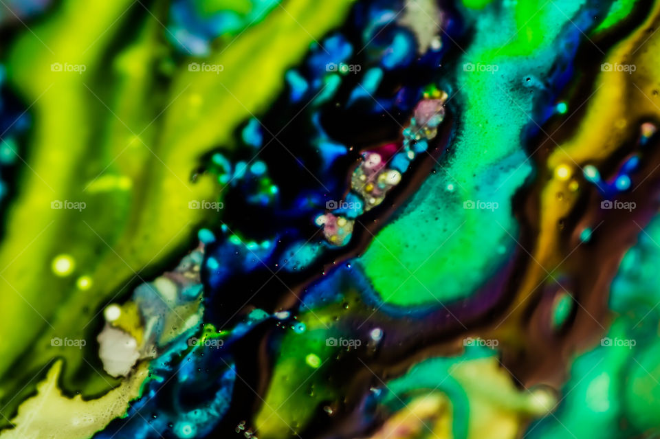 The ink to refill the printer cartridge was spilled onto the white washbasin and the paints blended into abstract drips and patterns.