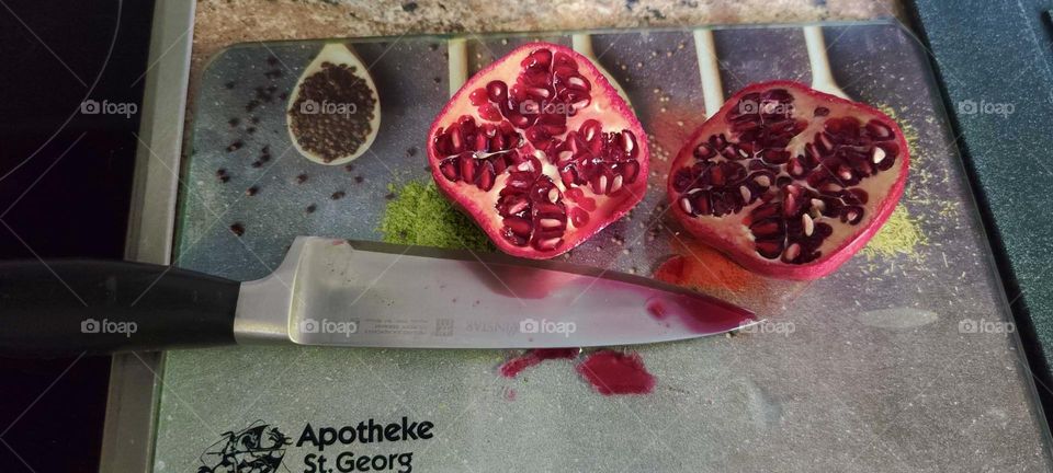 These freshly sliced pomegranates with the knife right below them on the cutting board come to us from a kitchen in “Bavaria”, Germany. 2024. Hypnotic Productions