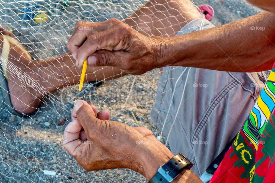 Person repairing fishing net