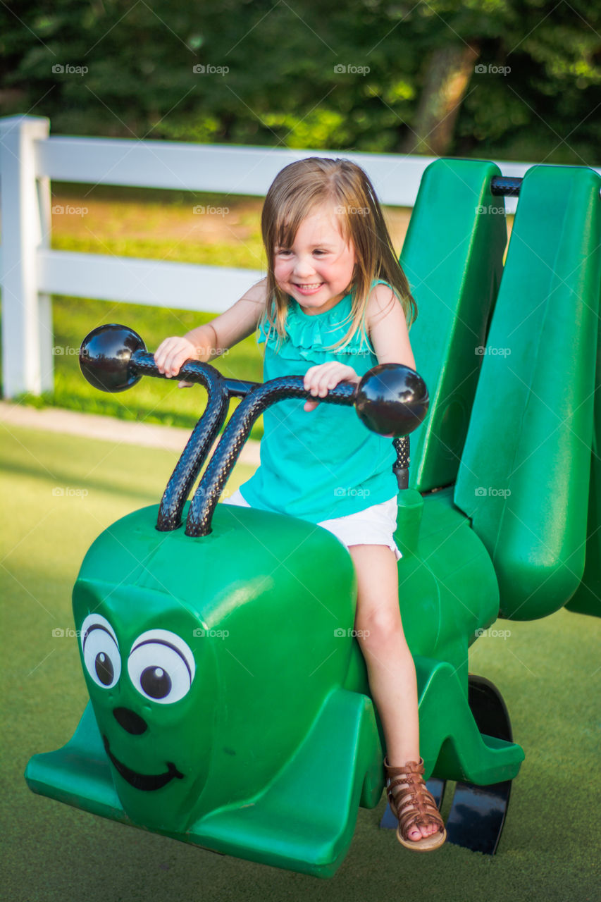 Young Girl on Green Caterpillar at the Playground 4