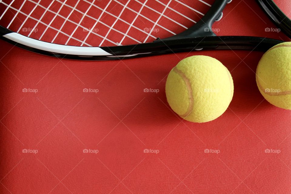 Tennis racket and balls on red background