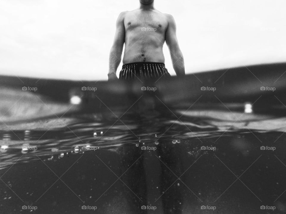 man below and above sea level. man standing,split shot of a man above and under sea level