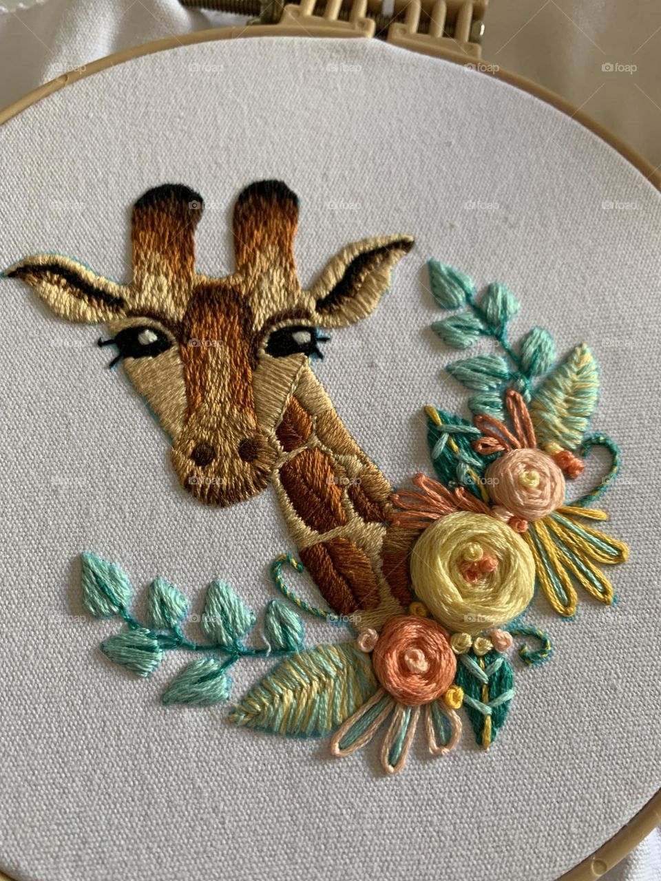 Adorable hand embroidered giraffe and pastel floral baby gift. Embellished with matching blue/green pom pom border. Suitable for decorating baby or child’s room.