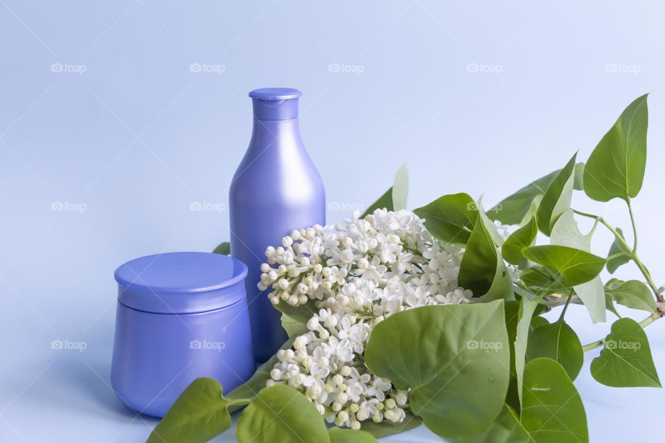 Two blue jars with space tools on a blue background and white lilac.