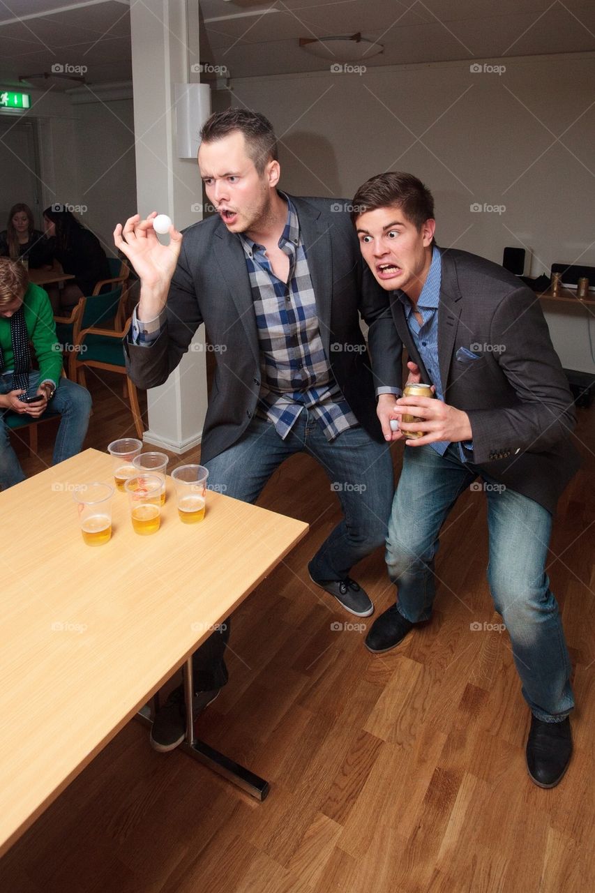 Two guys insanely focused on a game of beer pong