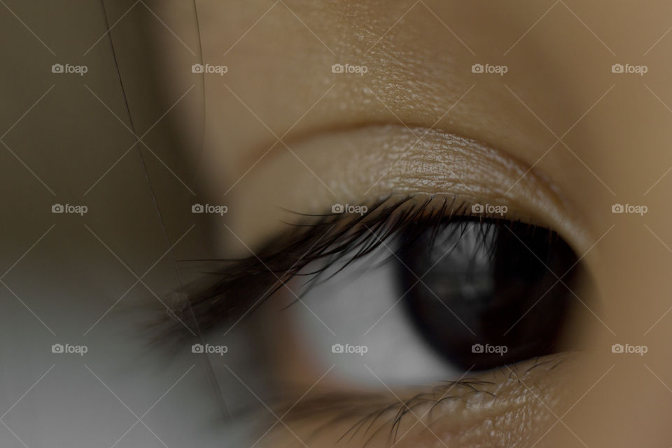 macro close up of deep black eye almond shape of a young Asian boy