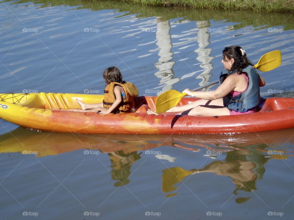 Woman and child enjoying a kayak on a summer day