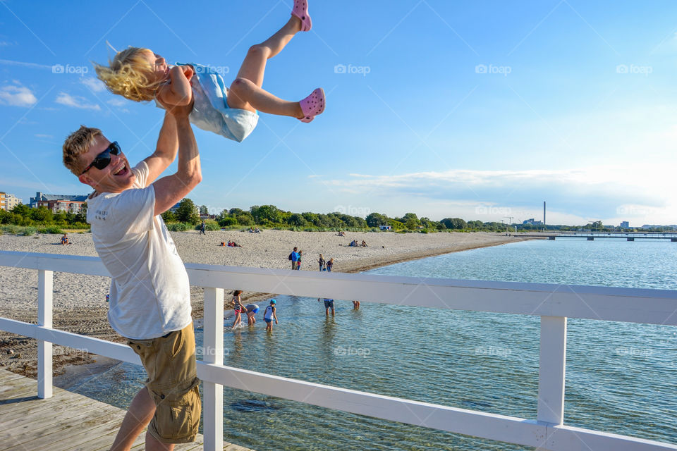 Smiling father lifting her daughter