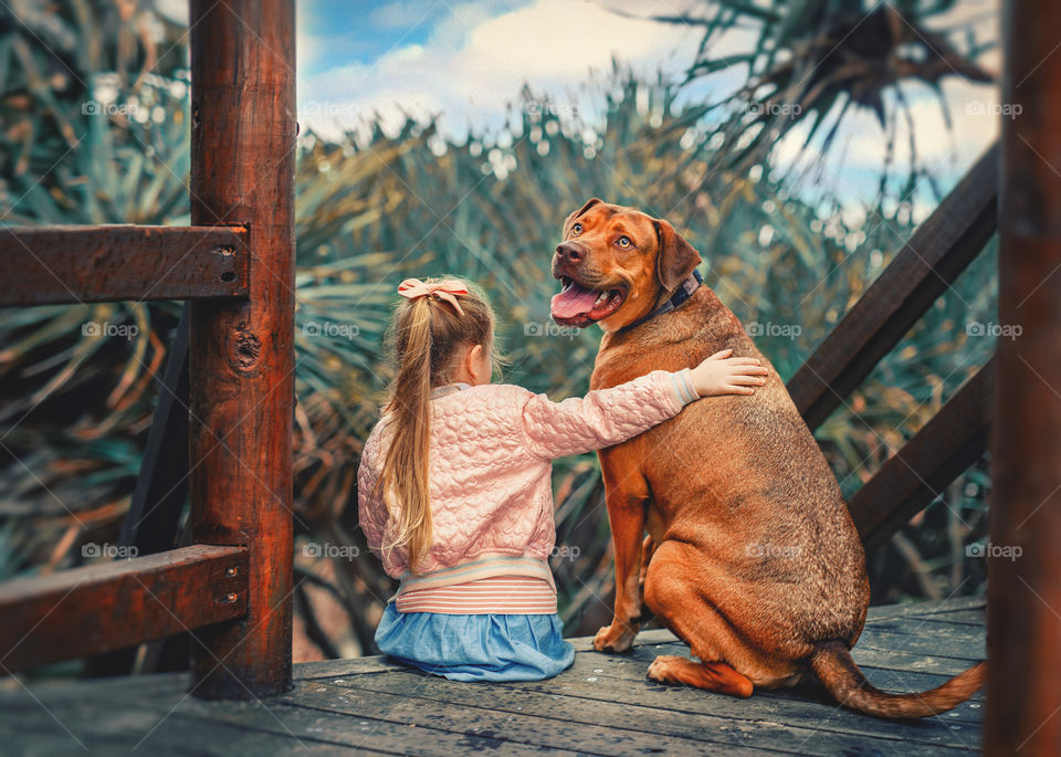 A little girl with a cute red dog