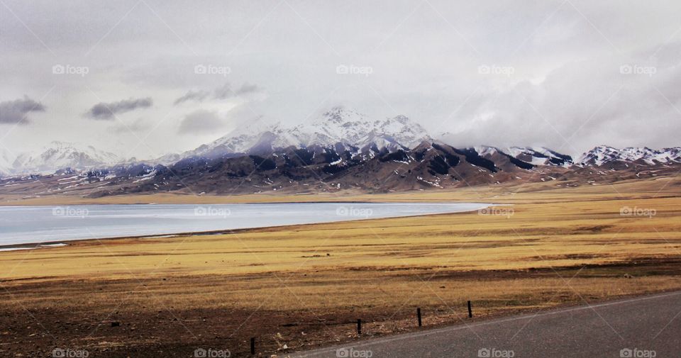 the snow capped mountains and fields in early spring