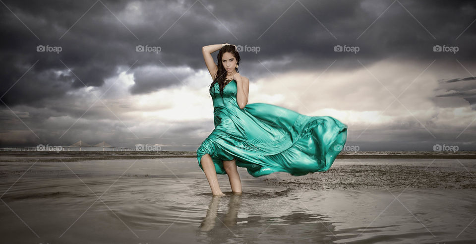 Beautiful young woman standing in water
