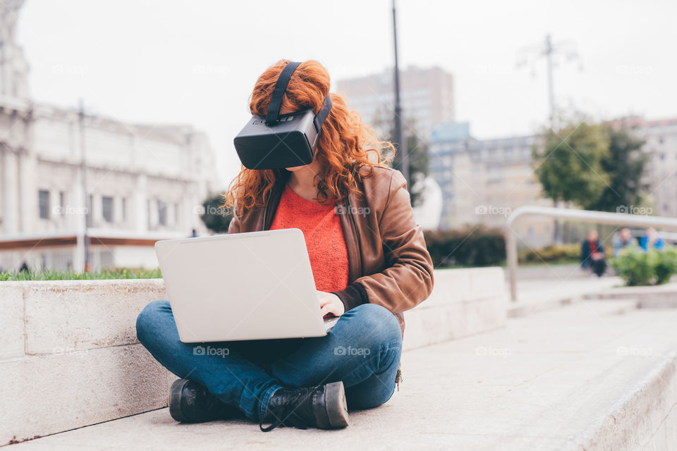 Woman using notebook and virtual viewer 3d in the city - studying, technology, gaming