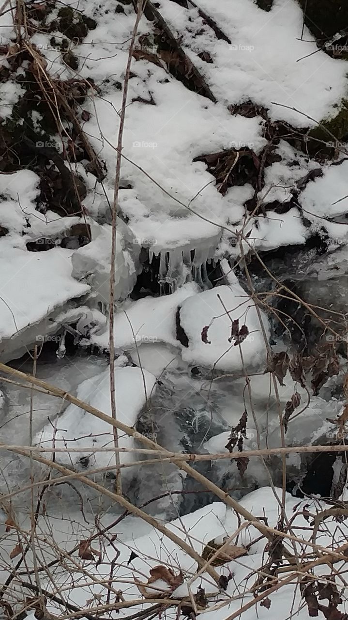 Thawing stream with icicles