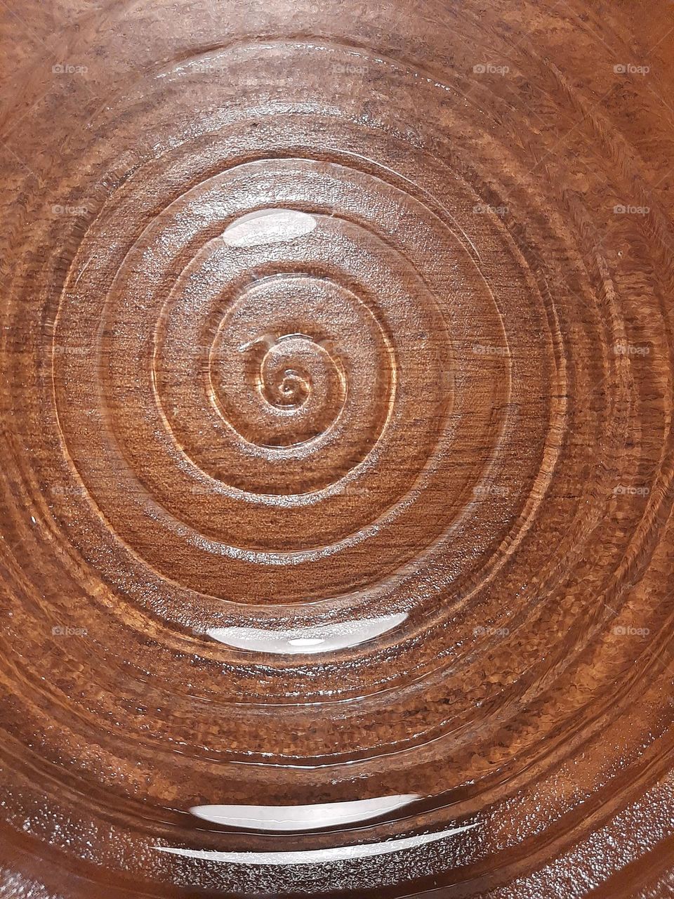 Circles of a hand blown glass ornament on a wooden table