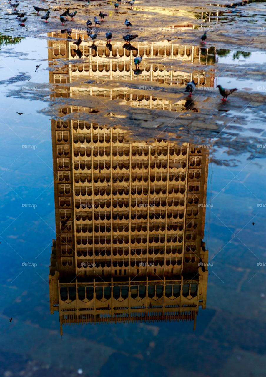 Reflection of architecture of iconic Taj Hotel of Mumbai in the rain water