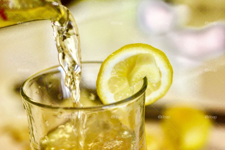 Pouring lemon ginger tea in the glass