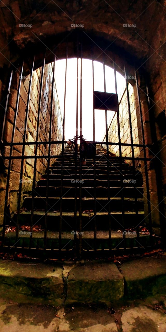 locked gate at bottom of stone staircase