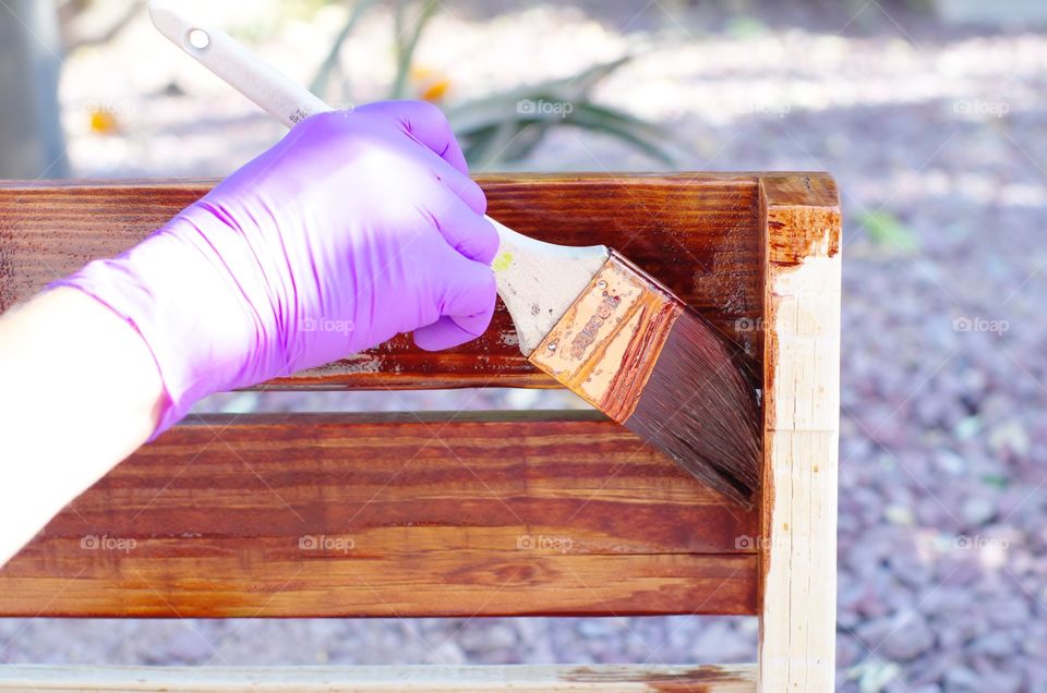 Applying wood stain to a homemade wine rack.