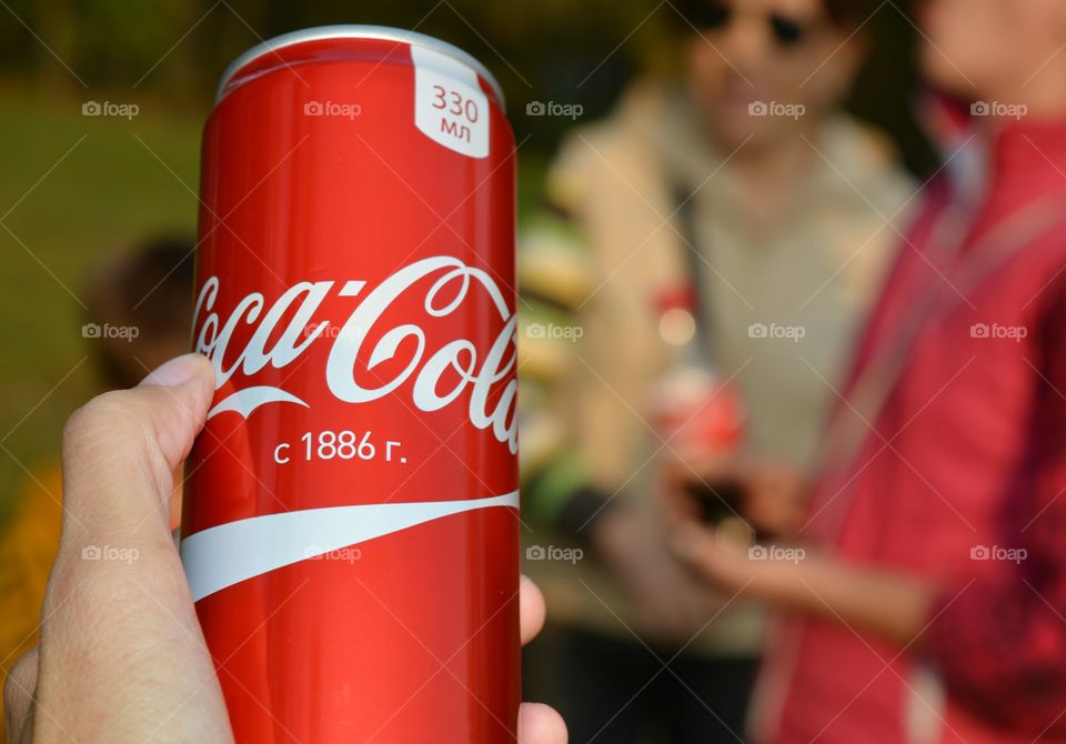 coca cola in hand and people, drinking coca cola outdoor