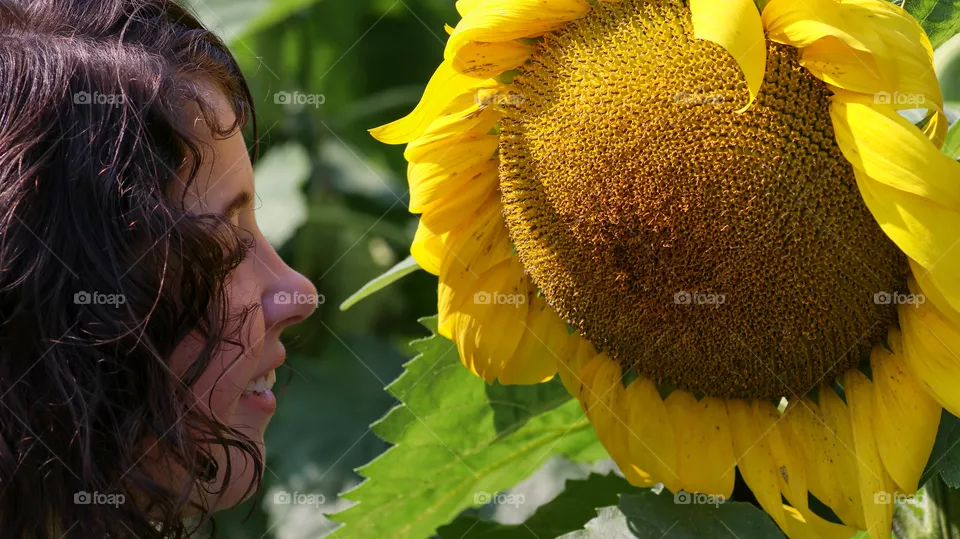 Girl looking at a giant sunflower