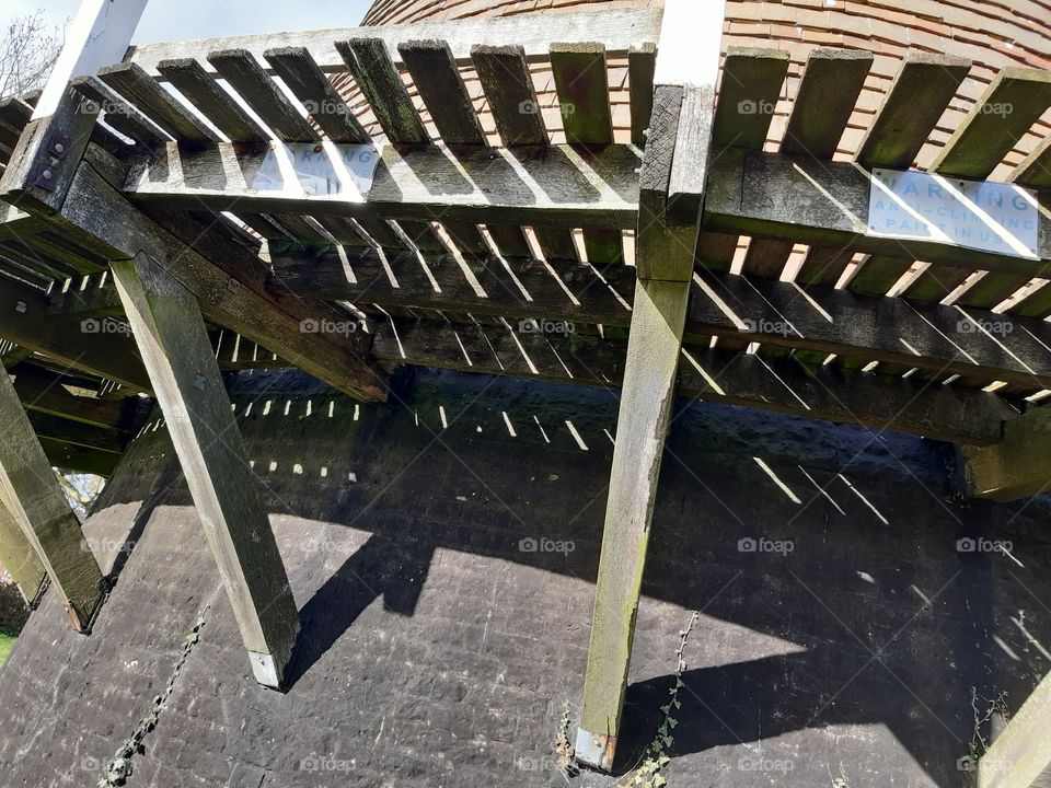 a supporting ledge of wooden slats running right around the circumference of an 18th century windmill just outside Eastbourne. The history has been re-written as two villages have argued over the rightful owners of this ancient windmill.