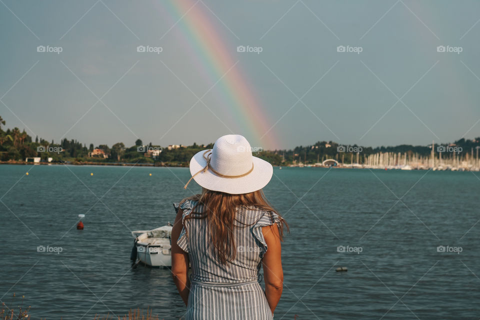 A woman watching sea and rainbow