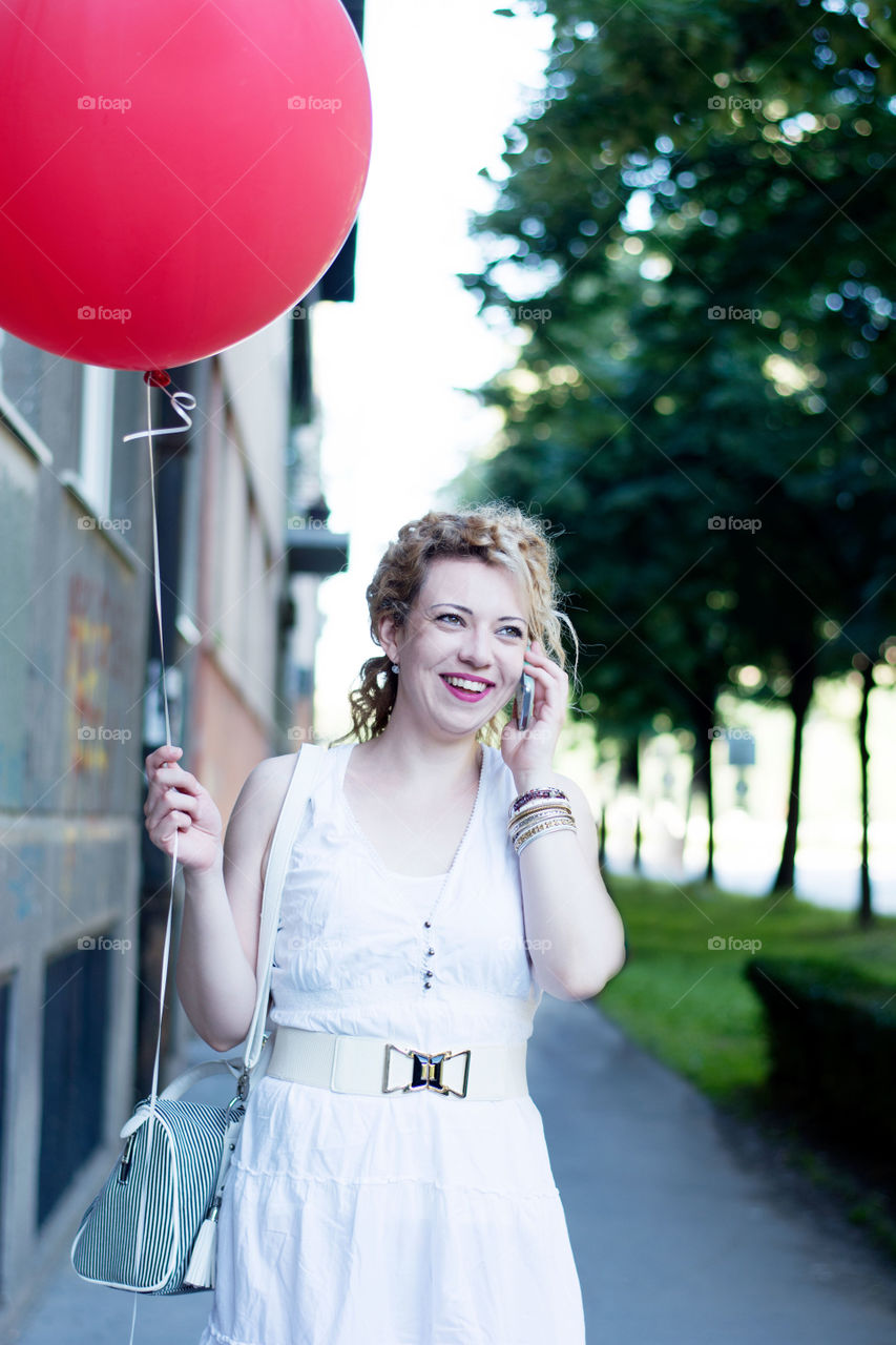 girl with red balloon. girl with big red balloon on the phone
