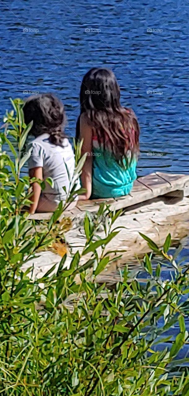 sitting on the dock at the lake enjoying the water