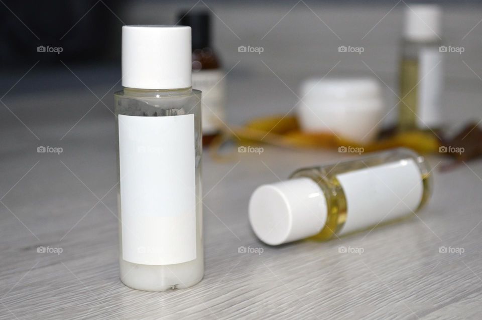 Jars with cream, shampoo and cosmetics on a background with autumn leaves