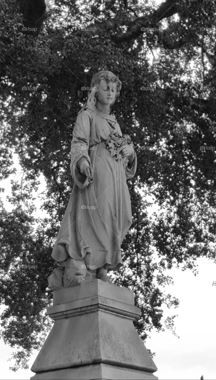 this is same photo I took but in black and white of a statue at the very top of a tall tombstone in Santa Clara Mission cemetery.