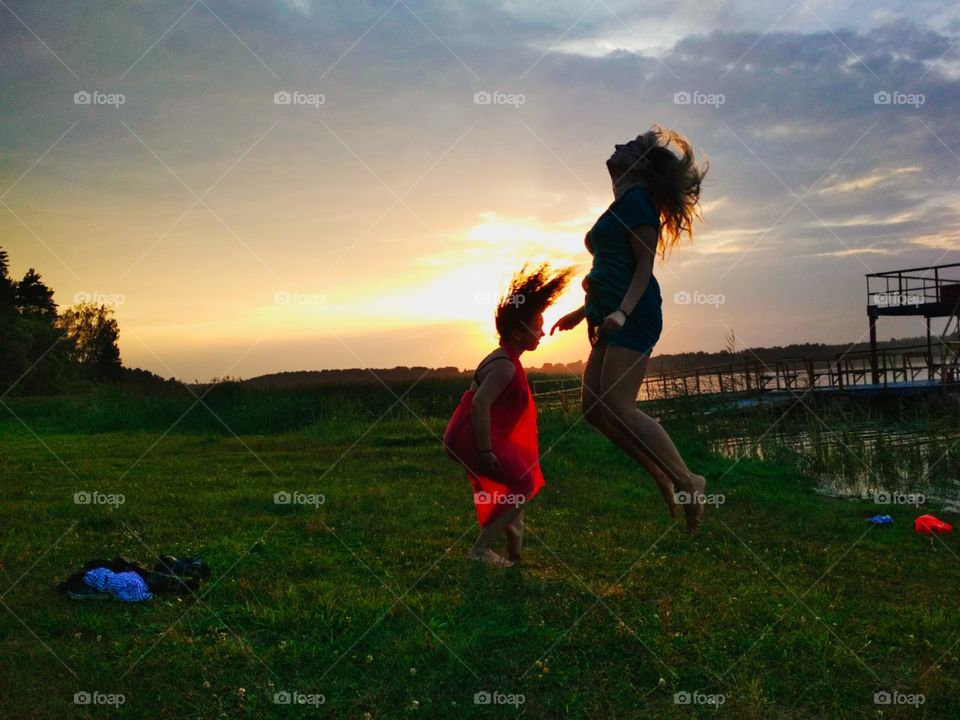 Две девушки танцуют на закате солнца