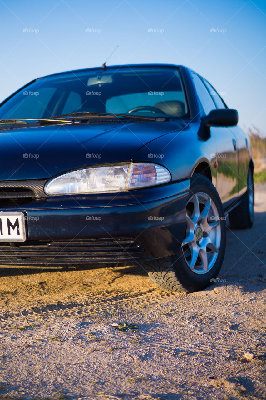 The car stands on the seashore at sunset