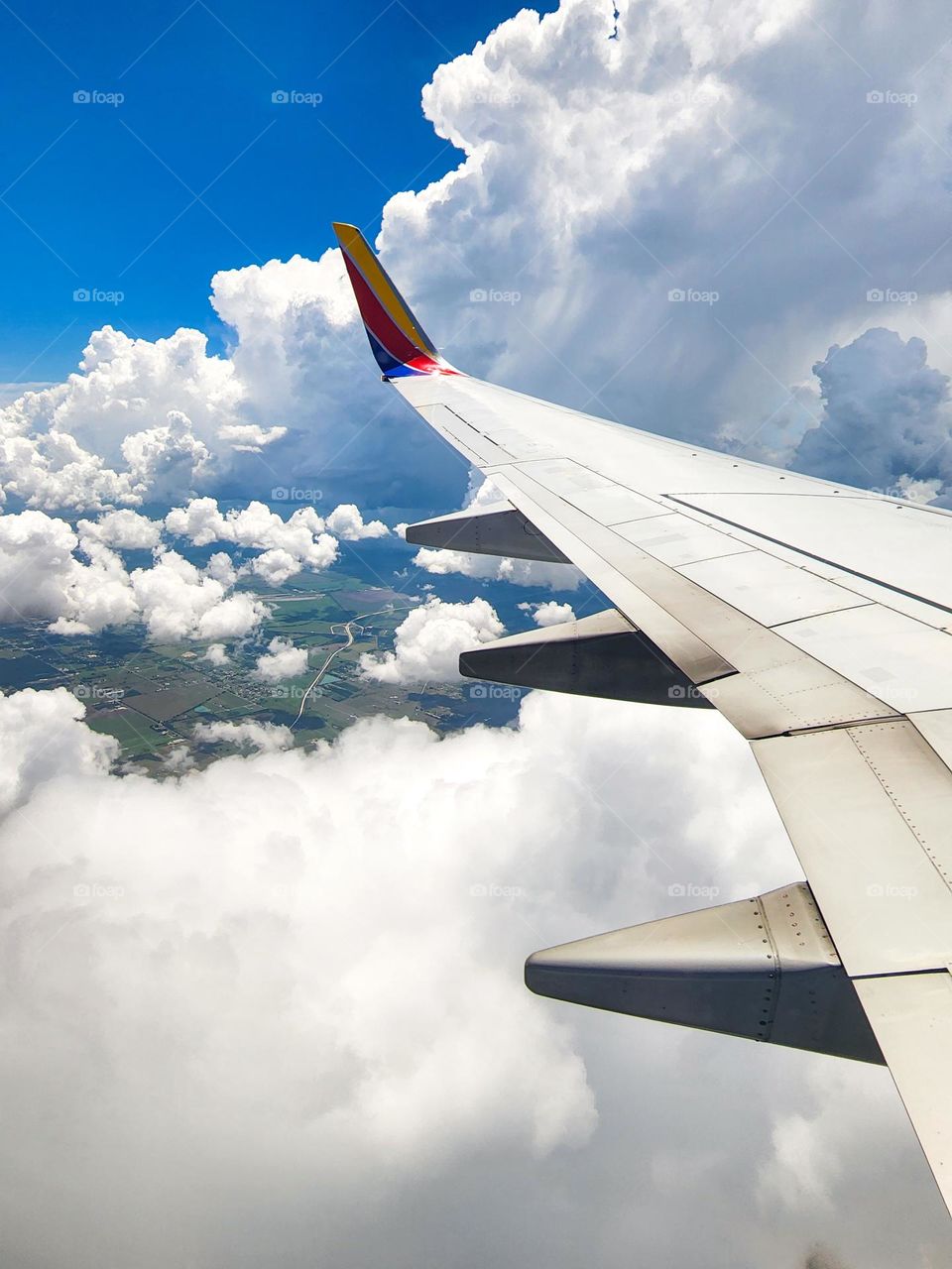 Massive towering clouds fill the sky as a Southwest 737 descends through the cloud cover
