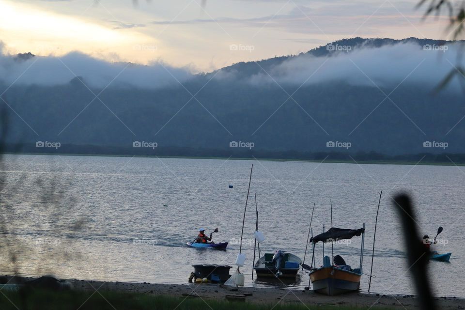 Kayaking activities with colourful kayak by the lake with far view hills 