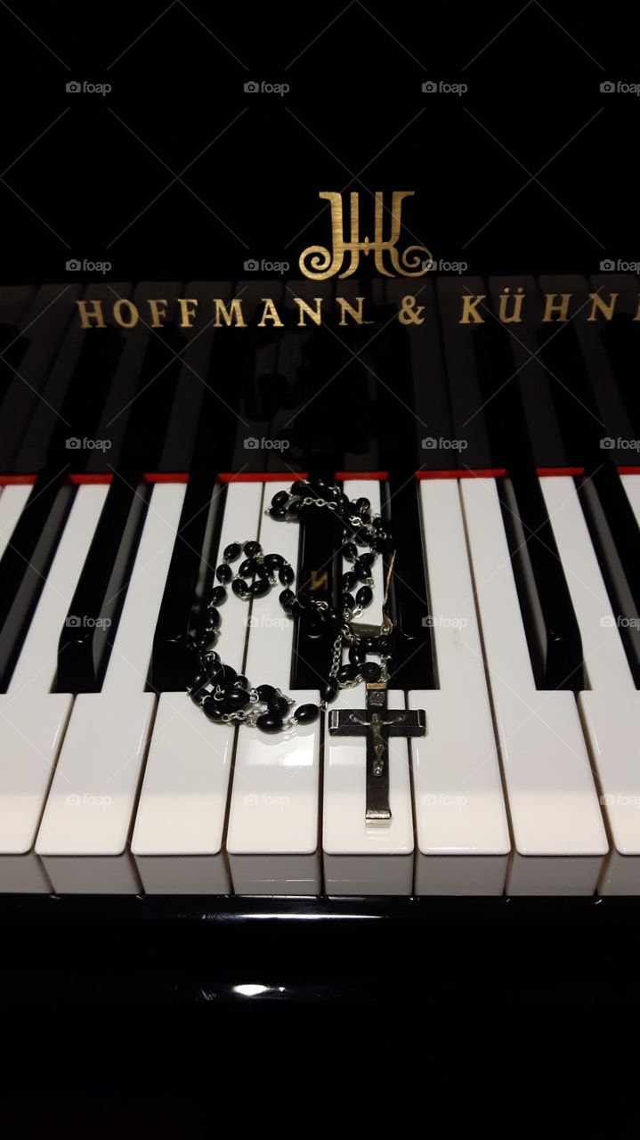 black rosary on piano keys