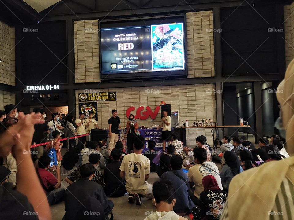 Karawang, Indonesia - September 2022: game event in the cinema lobby with the One Piece film screen above, before watching the One Piece film together in the Karawang cinema