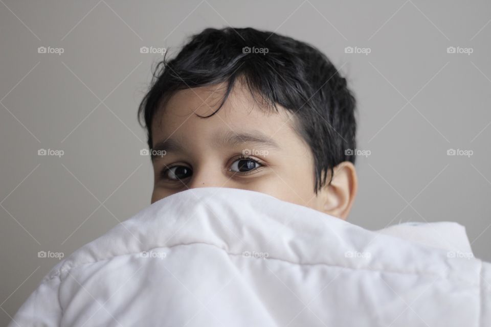 Kid having fun in winter holidays at home in bed 