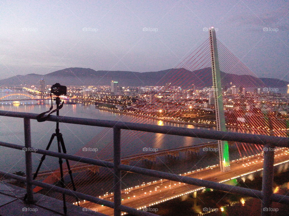 camera on tripod at a roof top in Danang taking long exposure shot in the evening