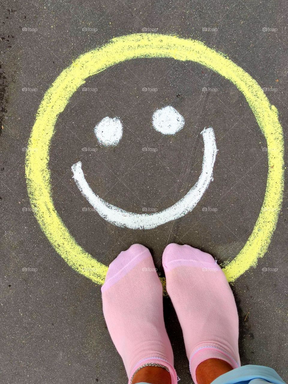 Happiness. A happy smiley face is drawn in chalk on the pavement, which smiles. Photo from which the beholder has a smile on his face and happy emotions