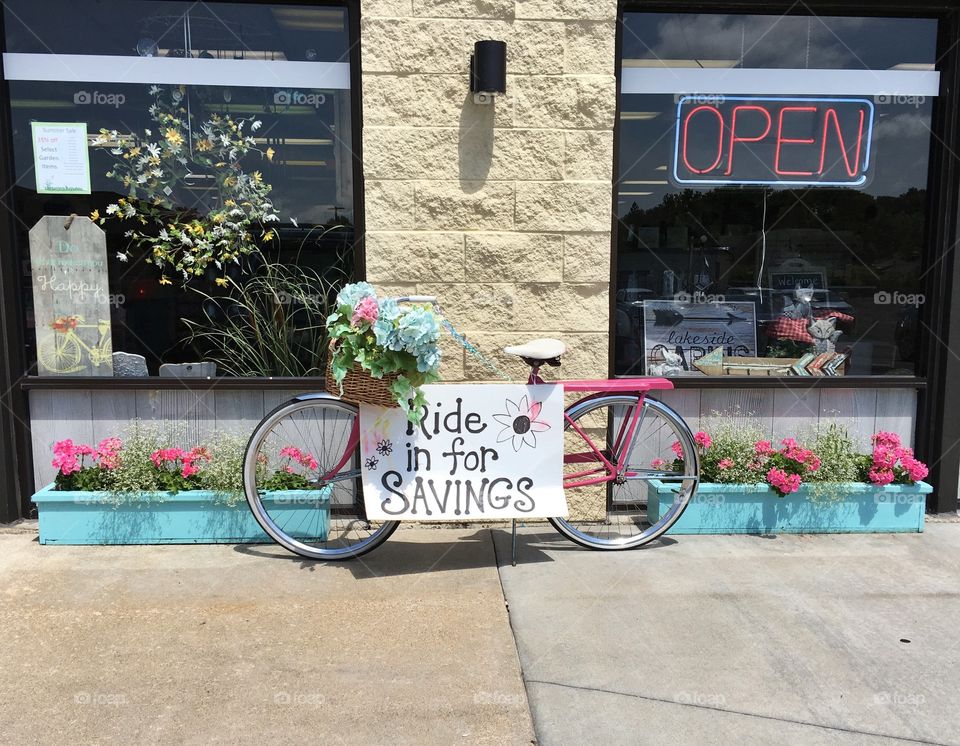 Bike being used as a sign for a store 