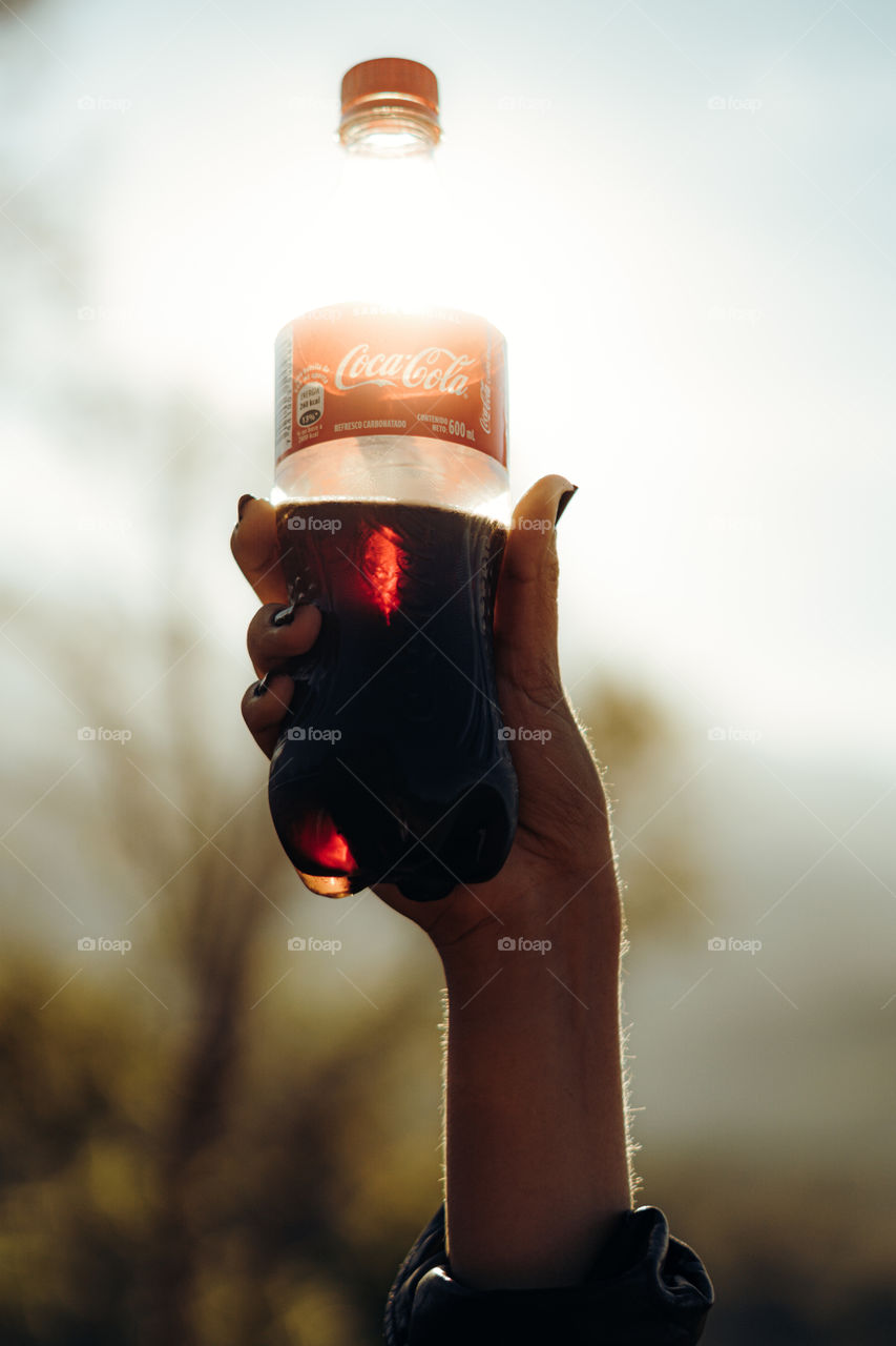 Person enjoying a delicious Coca Cola on a very sunny day